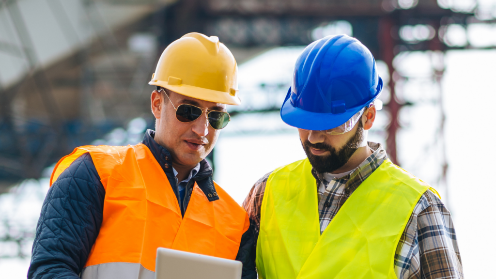 Two construction workers reading documentation