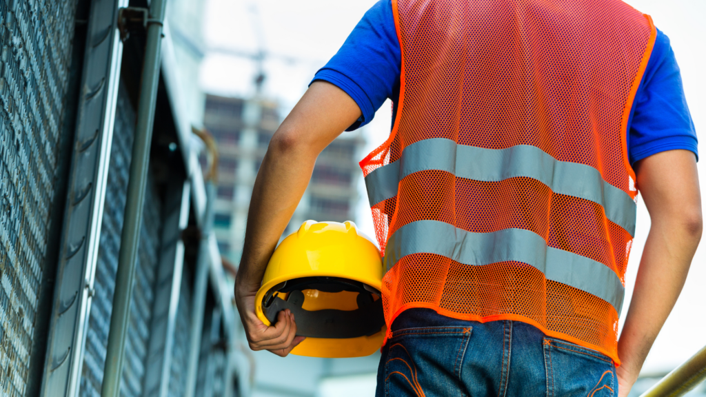 Man with yellow hardhat and orange safety vest